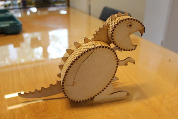 Modello di dinosauro con scatola di legno tagliata al laser